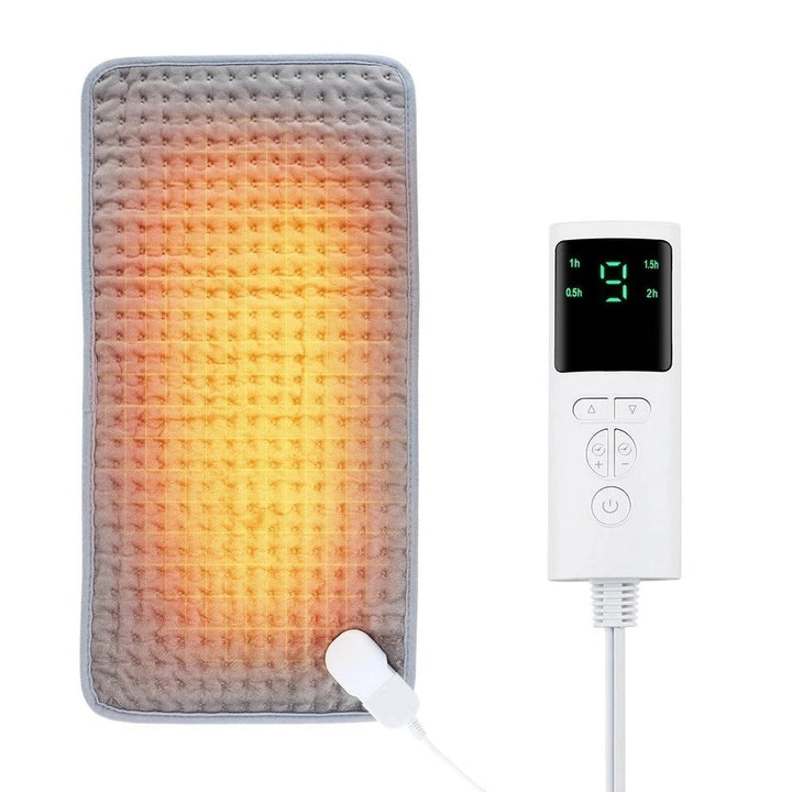 The image shows a digital remote control with an LCD display and several buttons, and a gray heating pad with an orange glow in the middle representing the heat