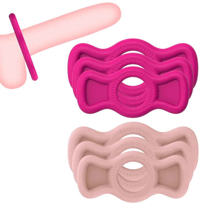 A group photo of a stack of magenta and a stack of pink flesh color premium cock rings with pullable side tabs