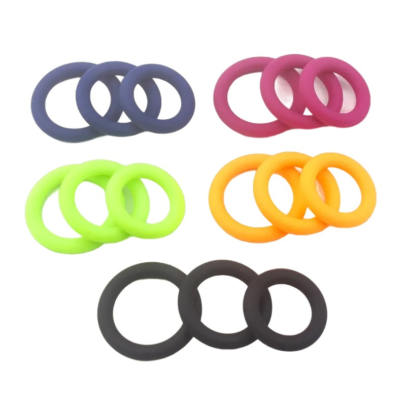A set of color-coded cock rings in rainbow colors, including black, blue, magenta, lime green, and tangerine orange. Each package of cock rings has three sizes and shapes with a small, medium, and large size design for penis pumping, soft clamping, and all day engorgement