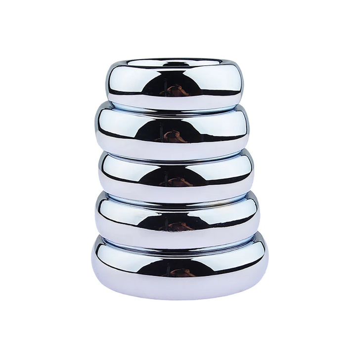 An image of a stack of steel cock rings ranging from the smallest on top to the largest on bottom