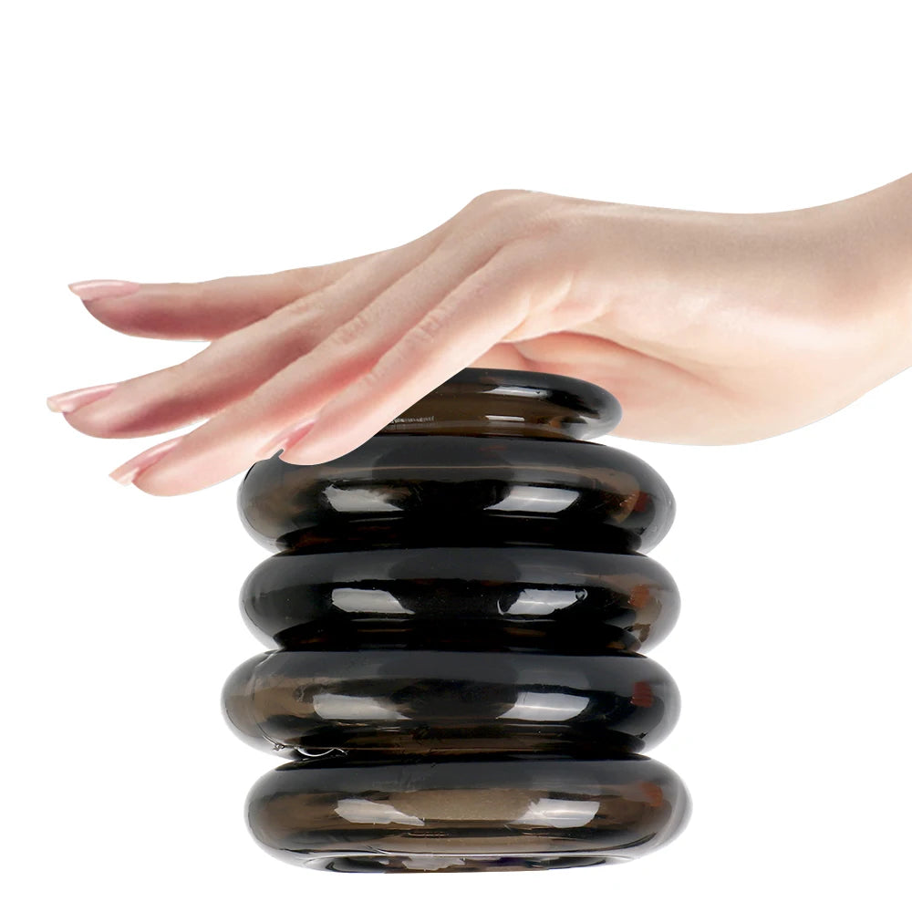 An image showing a woman placing her hand over a stack of four black interlocking cock rings