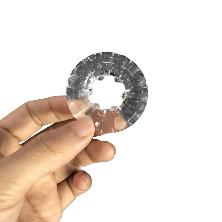 Man holding a clear silicone constriction ring against a white background