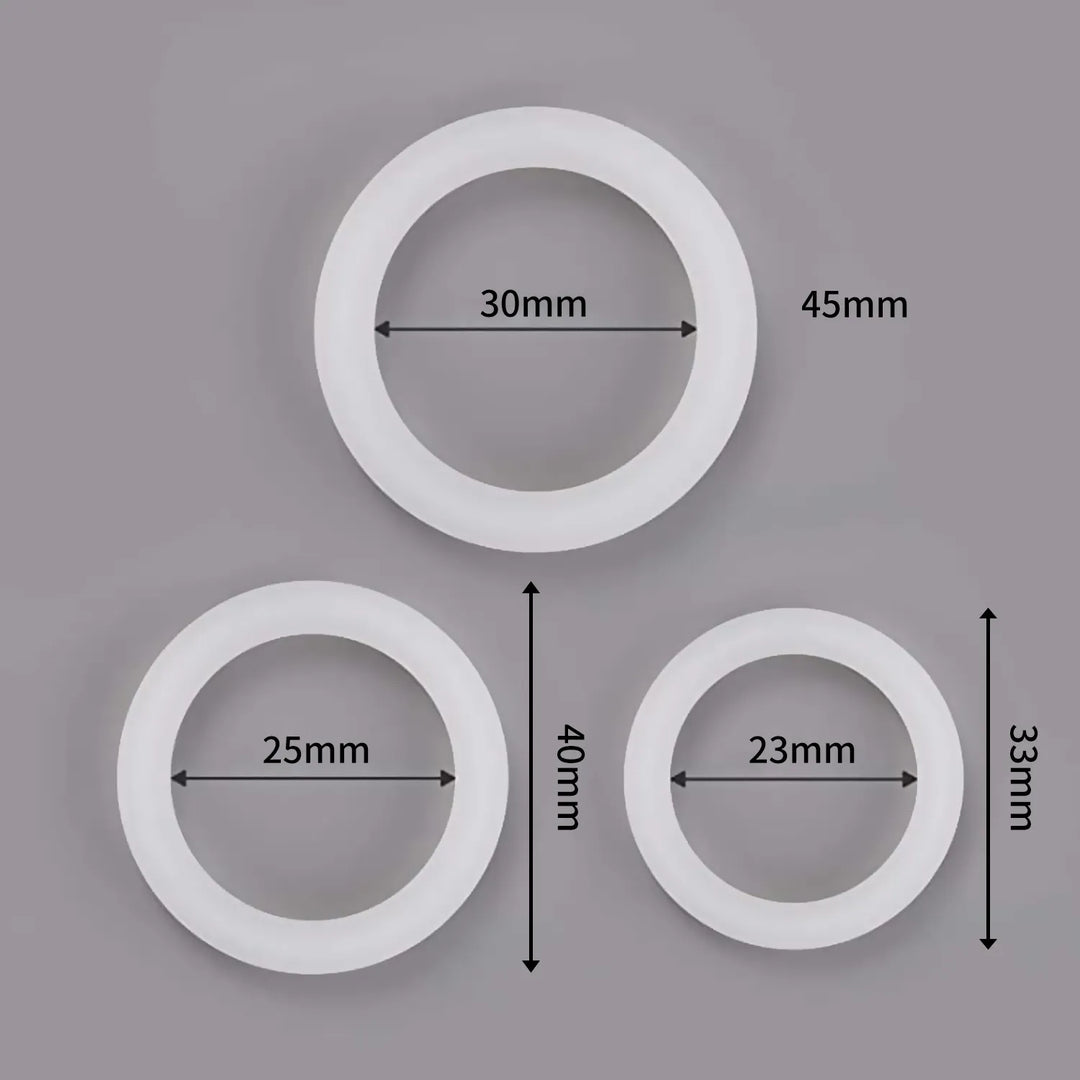An image showing three white glow in the dark cock rings and their varying dimensions with large size measuring 30 mm internal diameter and 45 mm width, medium size with 25 mm internal diameter and 40 mm width, and small size measuring 23 mm internal diameter and 33 mm width