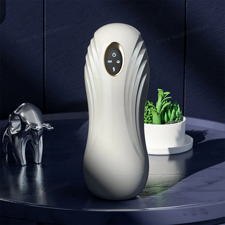 White color handheld masturbation device for men with a 4 button control panel at top on a table with other household items.