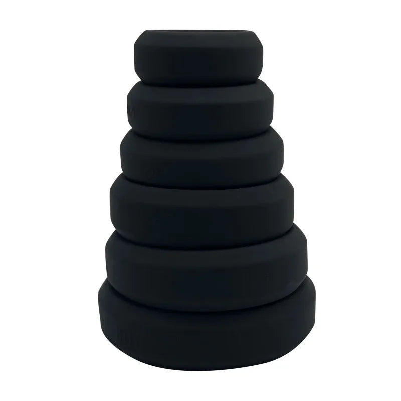 Full stack of six flat cock rings in black on a white background