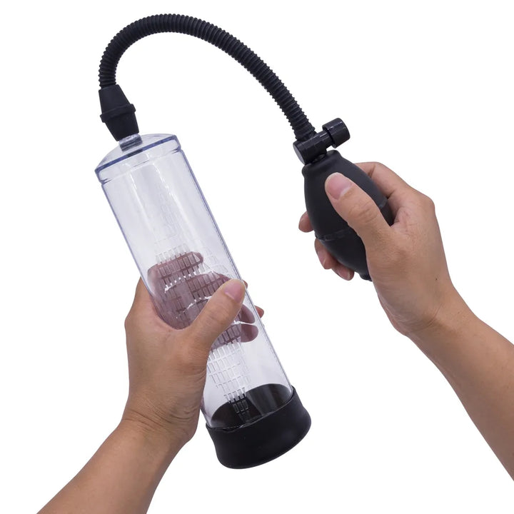 This image shows a man holding a starter manual-ball penis pump and squeezing the ball bulb pump to remove air from the cylinder