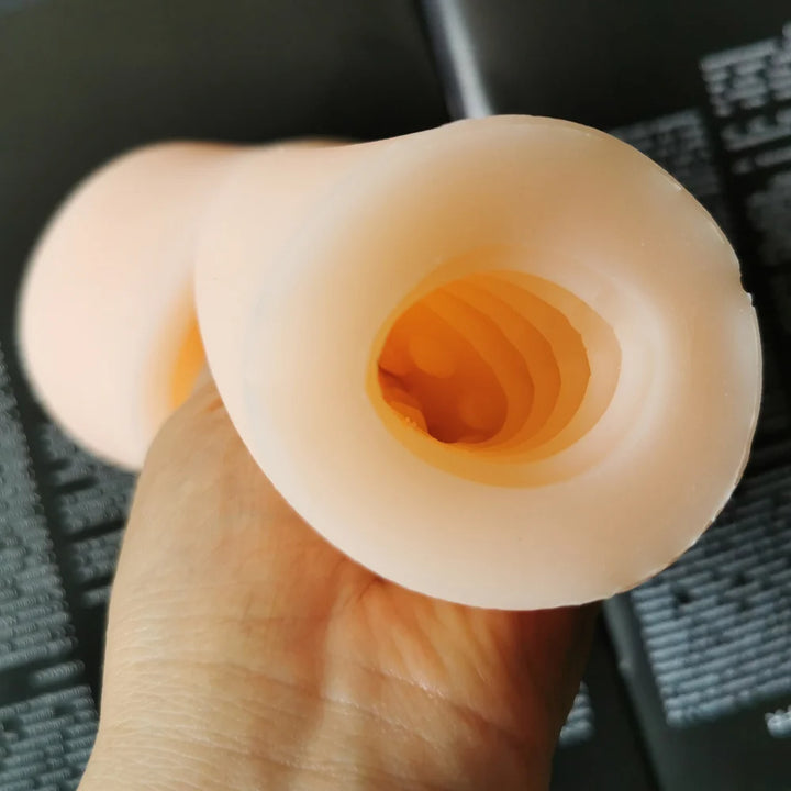 Image of a man holding the premium pleasure sleeve close to the camera to show the inner ridges, grooves, and textures that the penis would contact upon insertion