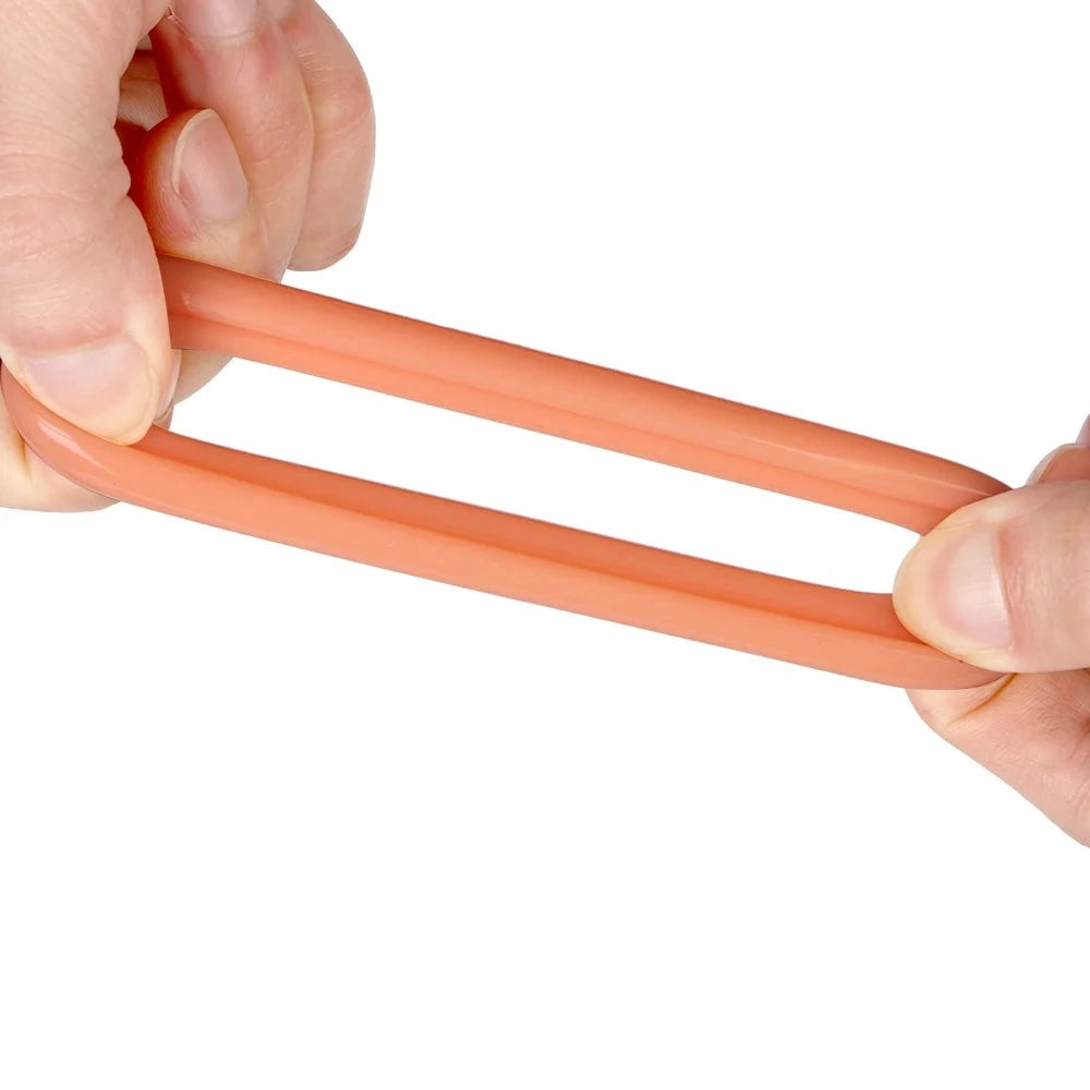 An image showing a flesh colored interlocking silicone cock ring being stretched and pulled apart to show its stretchiness by two hands of a man on a white background