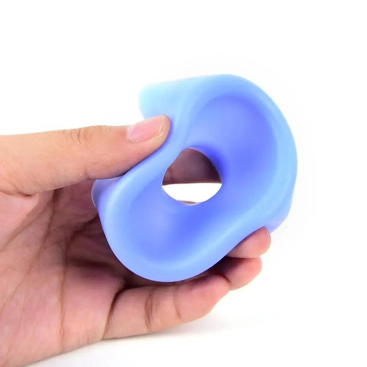 An image showing a light blue penis pump sleeve cover being gently squeezed by a man to show the soft, flexible silicone material