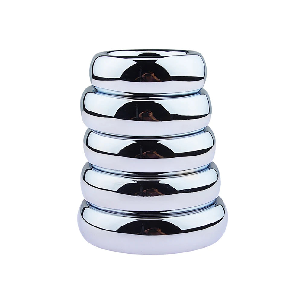 An image of a stack of steel cock rings ranging from the smallest on top to the largest on bottom