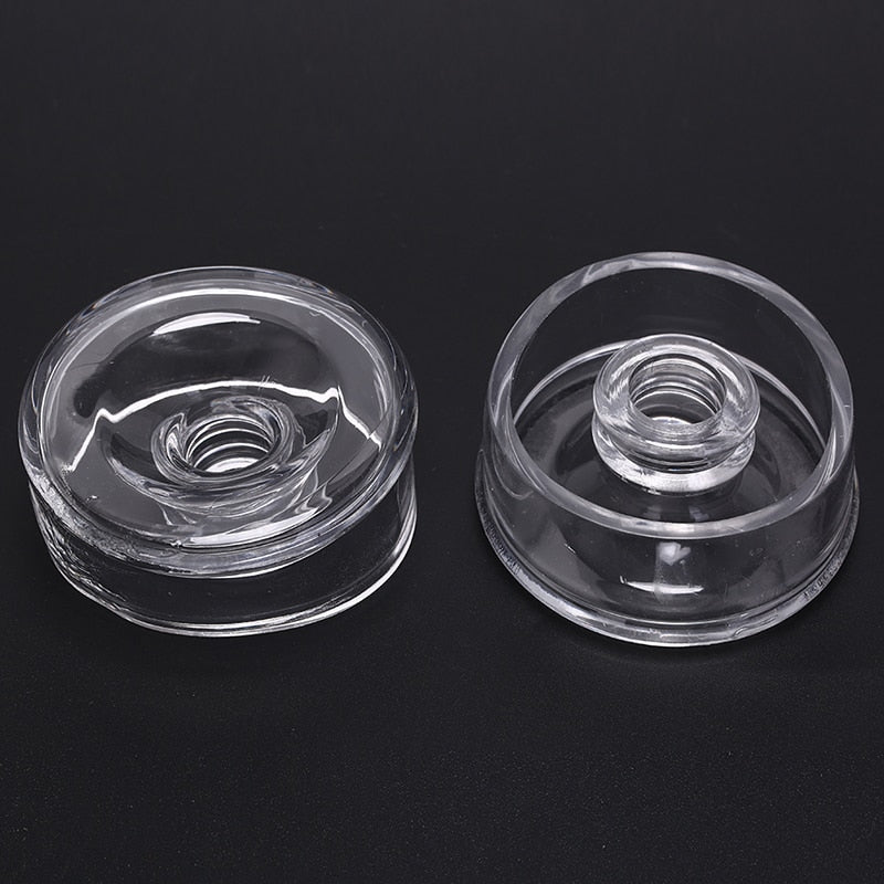 Two transparent clear silicone sleeve covers for a vacuum pump cylinder. One is facing up, showing the hole in which the penis is inserted, and the other is showing the bottom and inside, which is facing the inner chamber of the pump.