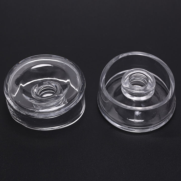 Two transparent clear silicone sleeve covers for a vacuum pump cylinder. One is facing up, showing the hole in which the penis is inserted, and the other is showing the bottom and inside, which is facing the inner chamber of the pump.